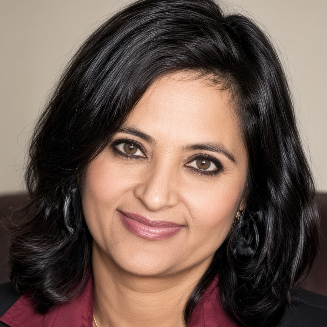 Close-up portrait of a smiling woman with dark hair and brown eyes, wearing a burgundy blouse and black blazer.