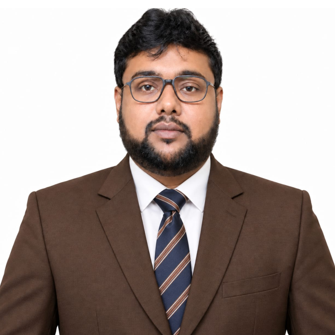 Professional headshot of a man with dark hair and a beard wearing brown suit, white shirt, and striped navy-blue tie against a white background.